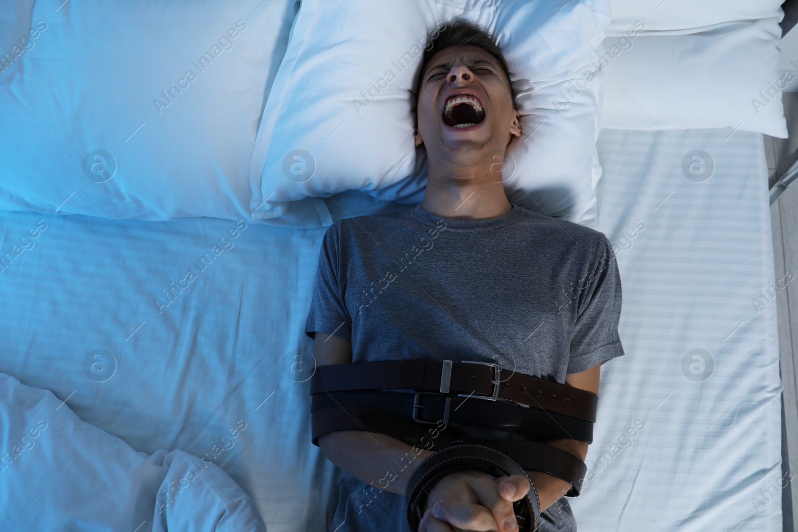 Photo of Man in sleepwalking condition screaming on bed, above view