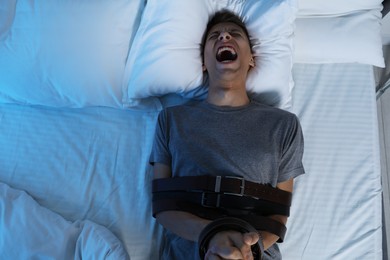 Photo of Man in sleepwalking condition screaming on bed, above view