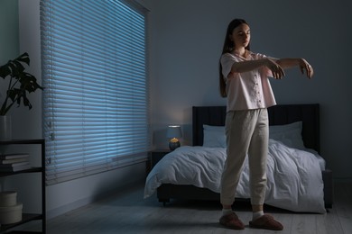 Young woman suffering from sleepwalking at home, space for text