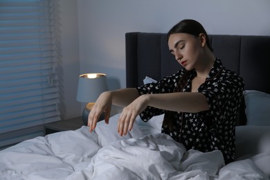 Photo of Young woman suffering from sleepwalking on bed at home