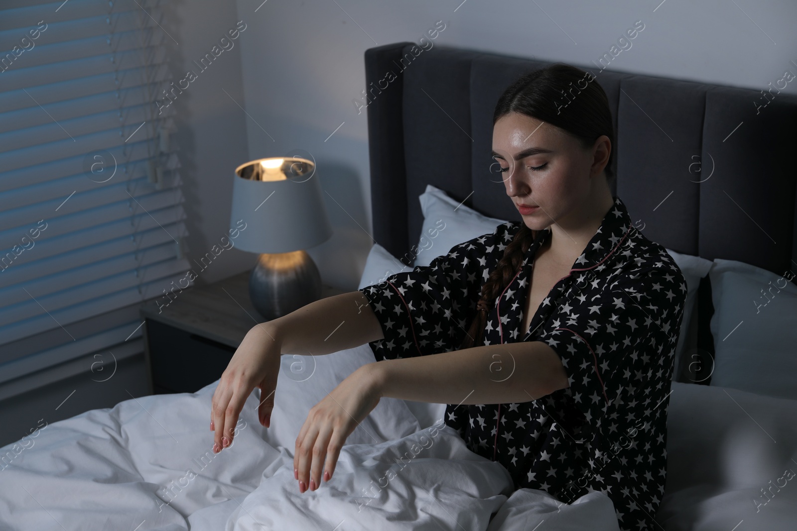 Photo of Young woman suffering from sleepwalking on bed at home