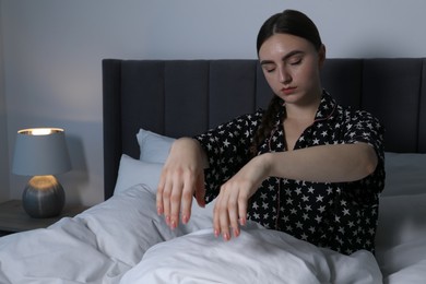 Photo of Young woman suffering from sleepwalking on bed at home