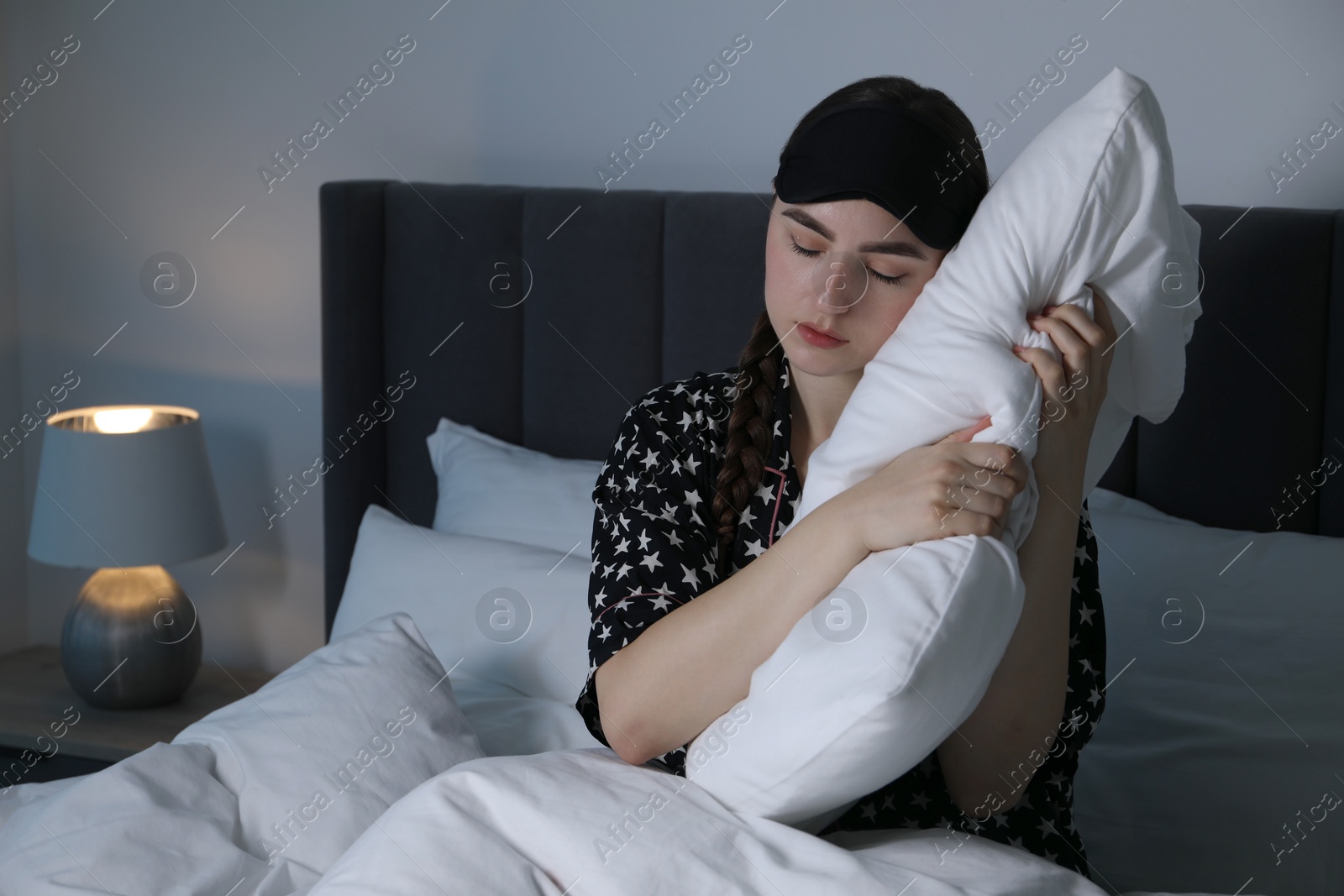 Photo of Young woman suffering from sleepwalking on bed at home