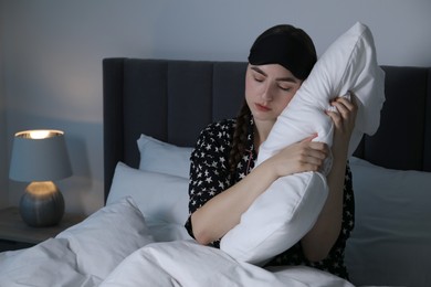 Photo of Young woman suffering from sleepwalking on bed at home