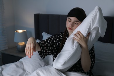 Photo of Young woman suffering from sleepwalking on bed at home