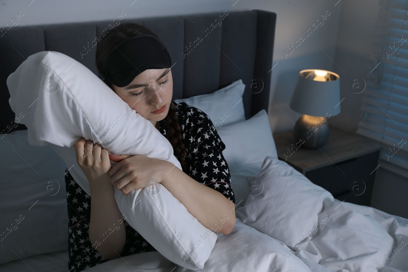 Photo of Young woman suffering from sleepwalking on bed at home