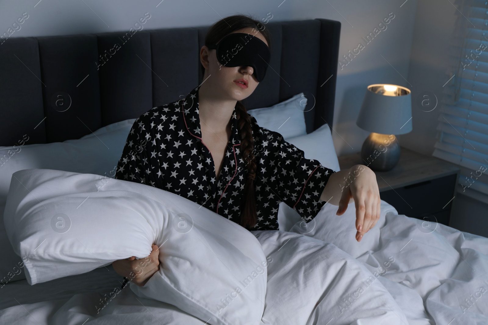 Photo of Young woman suffering from sleepwalking on bed at home