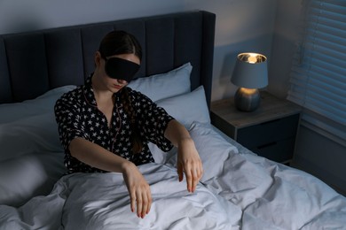 Photo of Young woman suffering from sleepwalking on bed at home