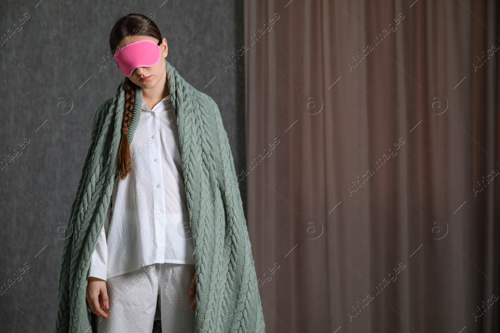 Photo of Young woman suffering from sleepwalking at home, space for text