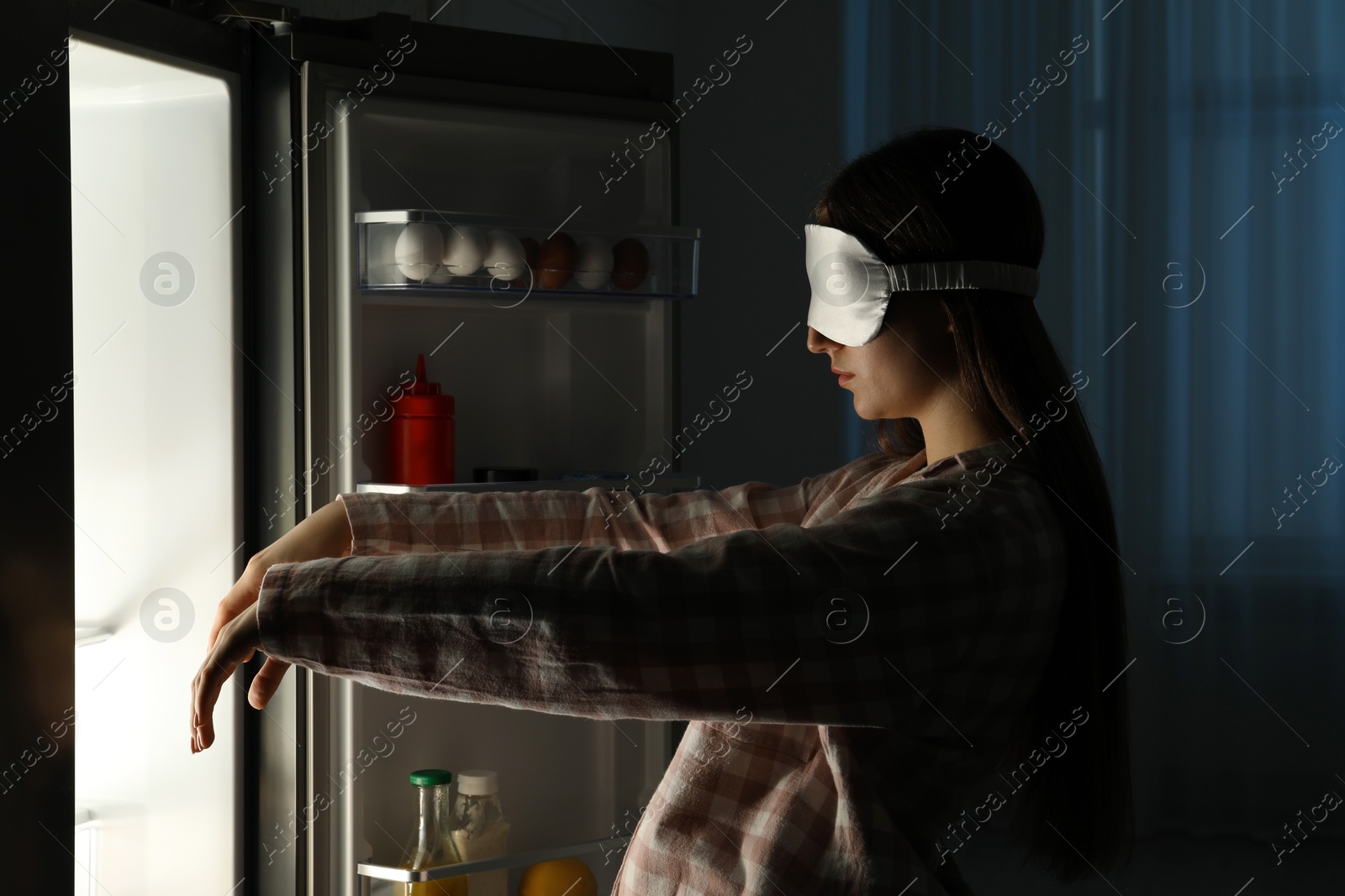 Photo of Young woman suffering from sleepwalking near fridge at home