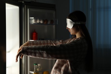 Photo of Young woman suffering from sleepwalking near fridge at home