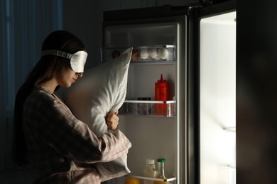 Photo of Young woman suffering from sleepwalking near fridge at home