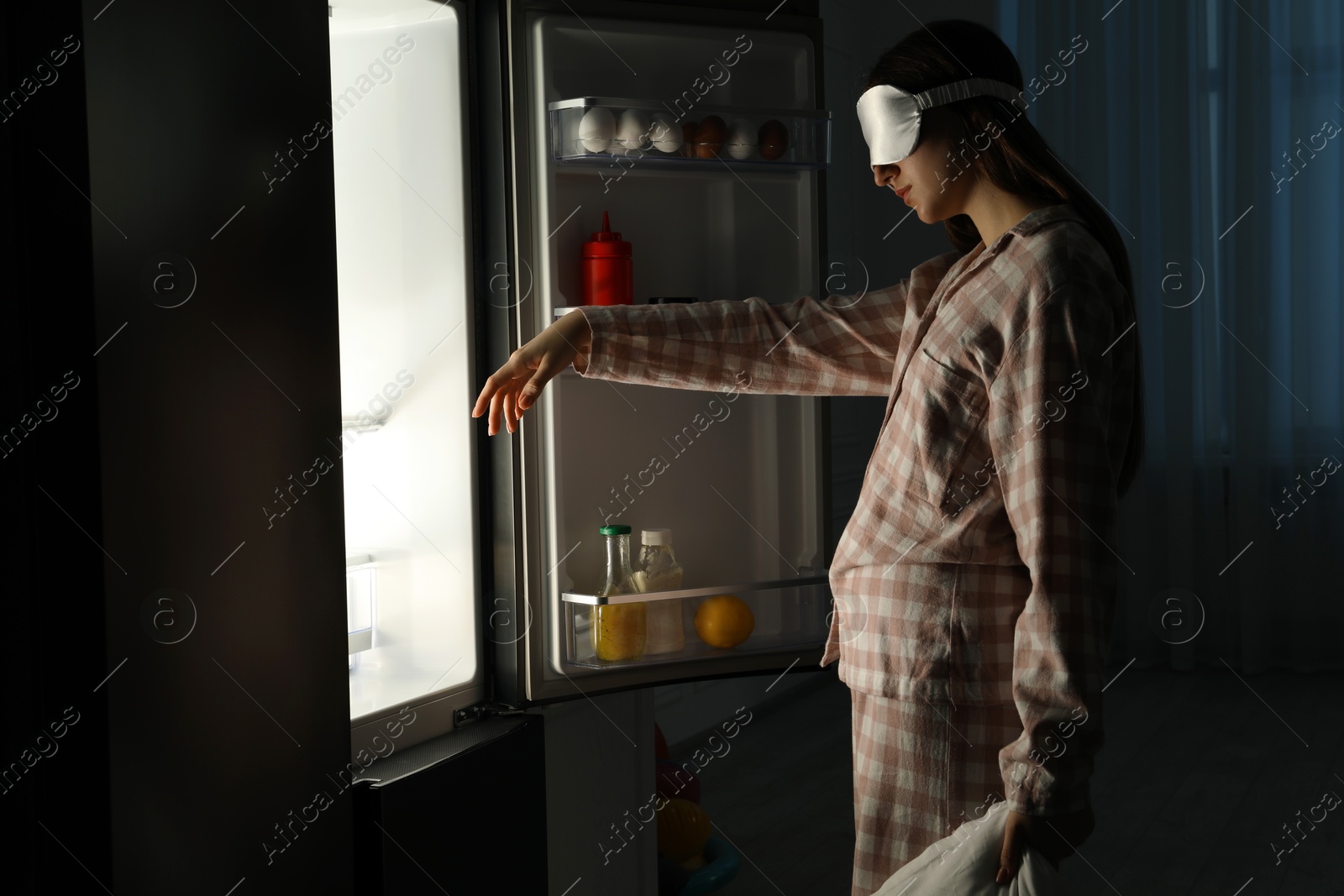 Photo of Young woman suffering from sleepwalking near fridge at home