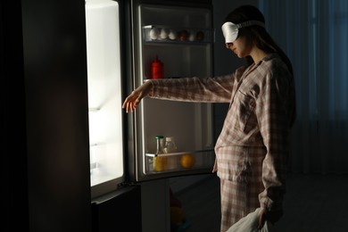 Photo of Young woman suffering from sleepwalking near fridge at home