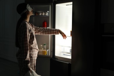 Photo of Young woman suffering from sleepwalking near fridge at home