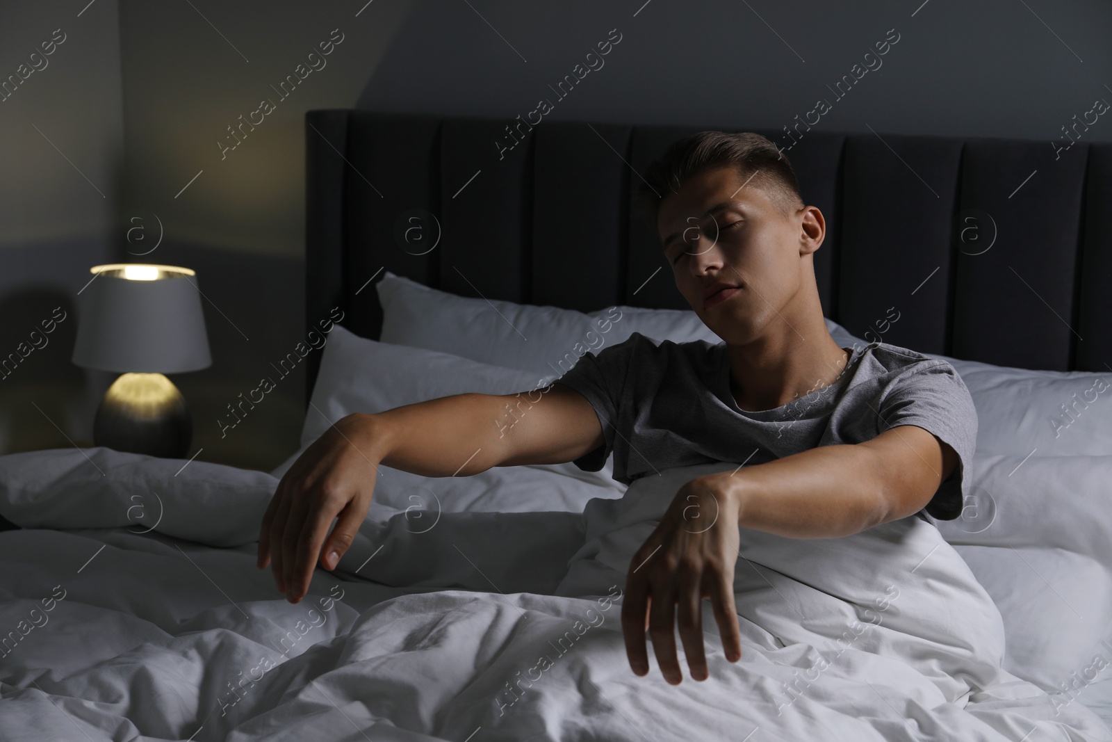 Photo of Young man suffering from sleepwalking on bed at home