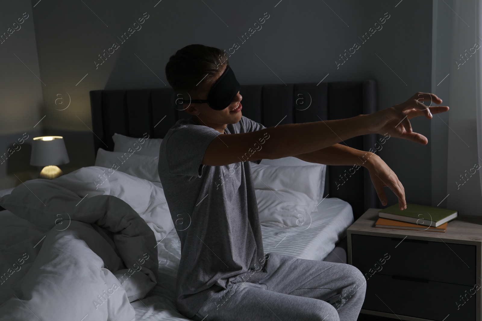 Photo of Young man suffering from sleepwalking on bed at home