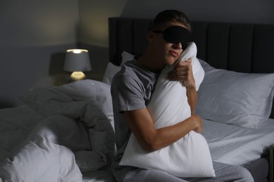 Photo of Young man suffering from sleepwalking on bed at home