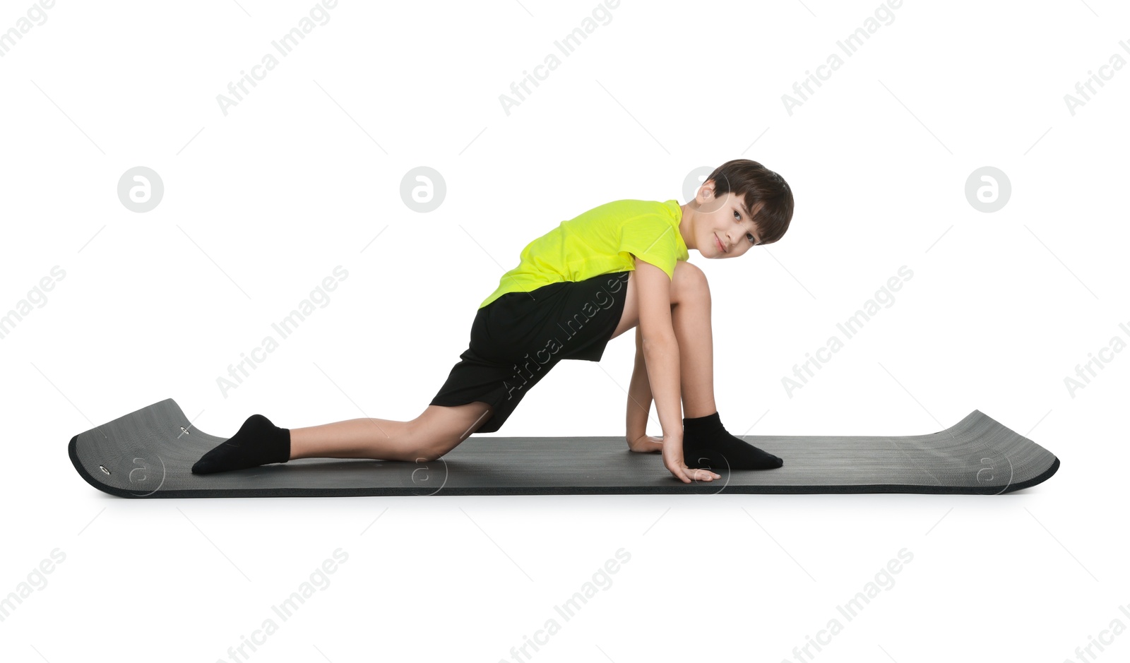 Photo of Boy exercising on fitness mat against white background. Sport activity