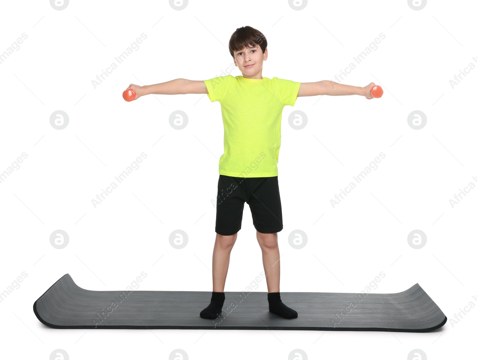 Photo of Boy exercising with dumbbells on fitness mat against white background. Sport activity