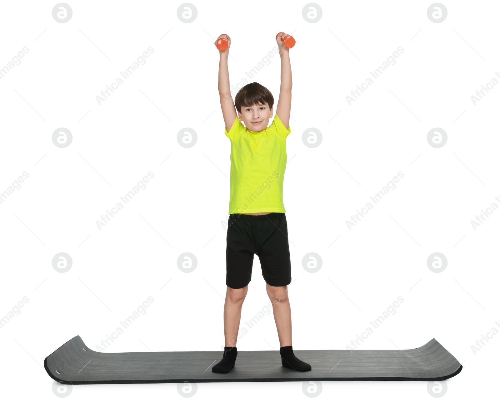 Photo of Boy exercising with dumbbells on fitness mat against white background. Sport activity