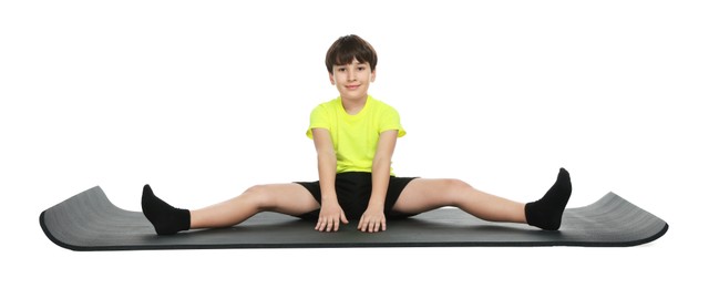 Photo of Boy exercising on fitness mat against white background. Sport activity