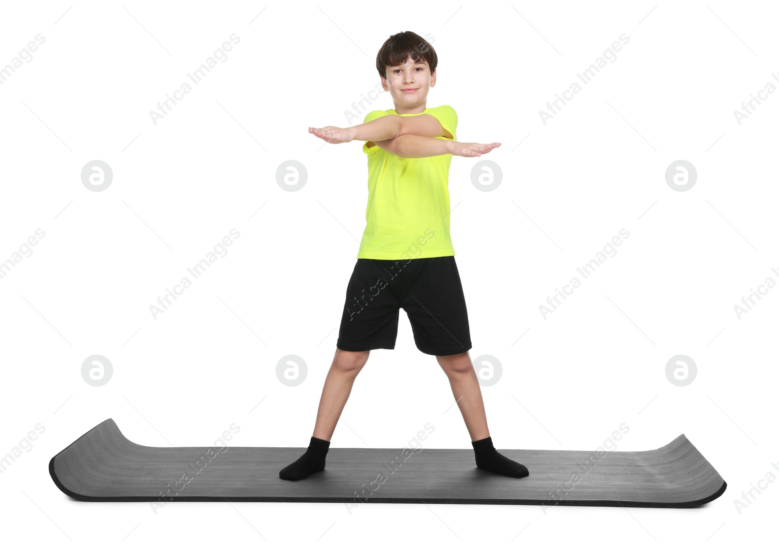 Photo of Boy exercising on fitness mat against white background. Sport activity