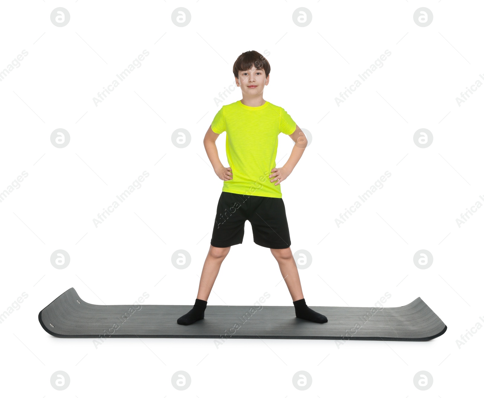 Photo of Boy exercising on fitness mat against white background. Sport activity