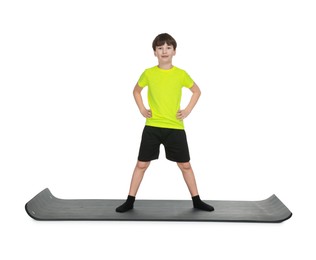 Photo of Boy exercising on fitness mat against white background. Sport activity