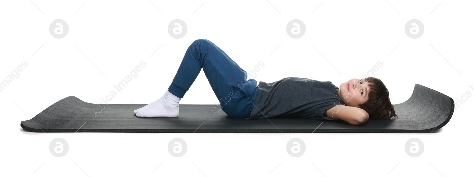 Photo of Boy exercising on fitness mat against white background. Sport activity