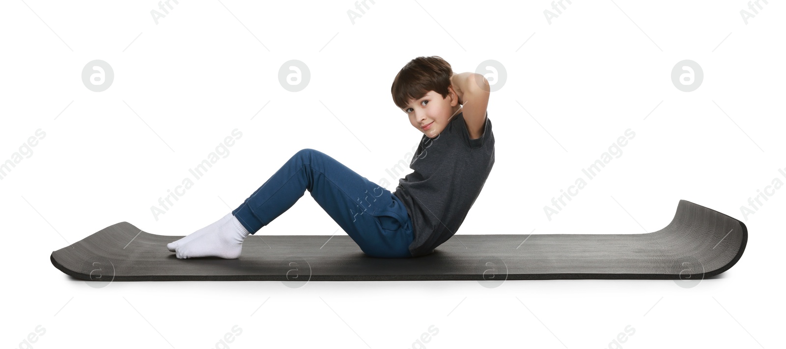 Photo of Boy exercising on fitness mat against white background. Sport activity