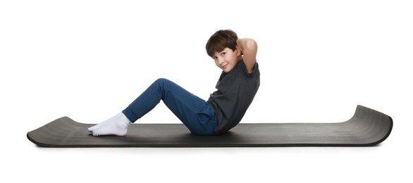 Photo of Boy exercising on fitness mat against white background. Sport activity