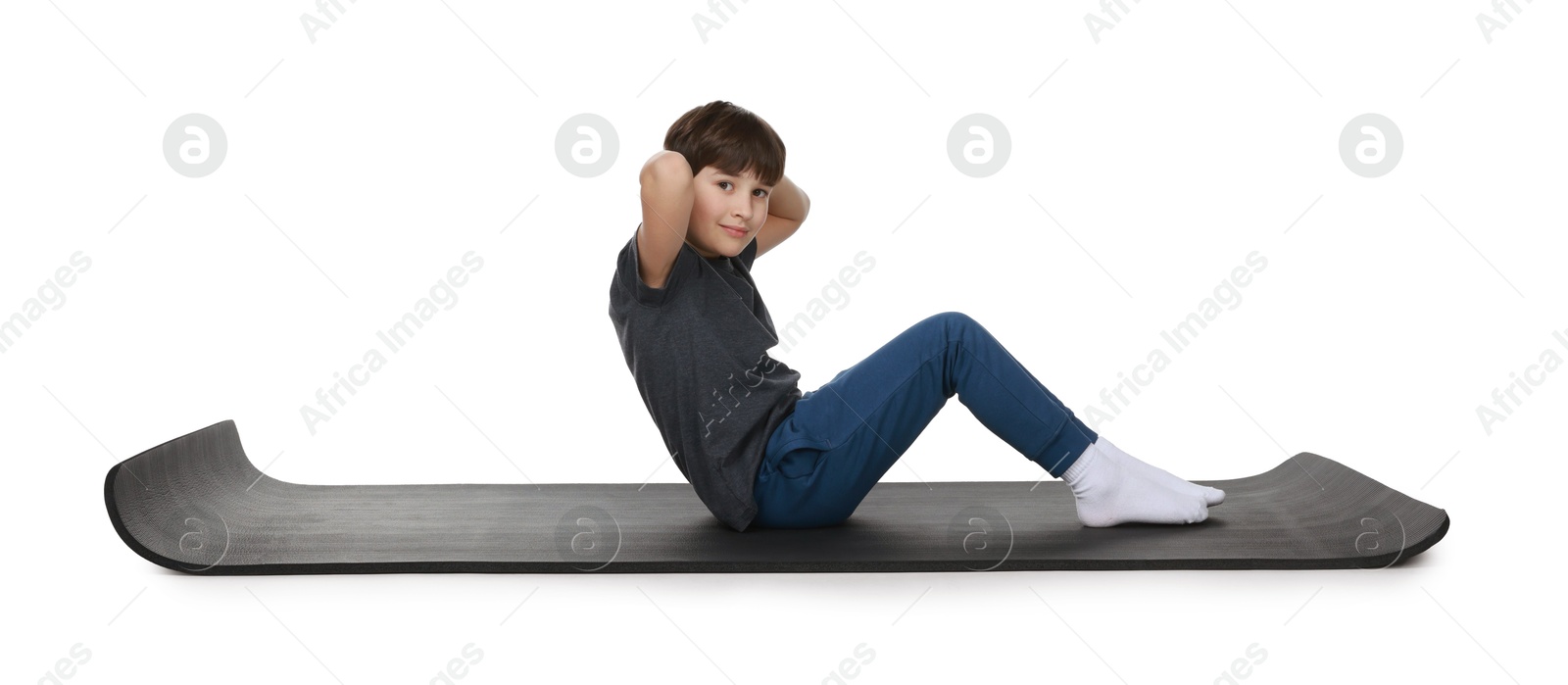 Photo of Boy exercising on fitness mat against white background. Sport activity