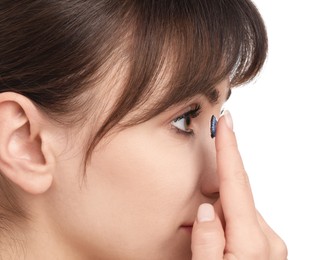 Photo of Woman putting in blue color contact lens on white background, closeup