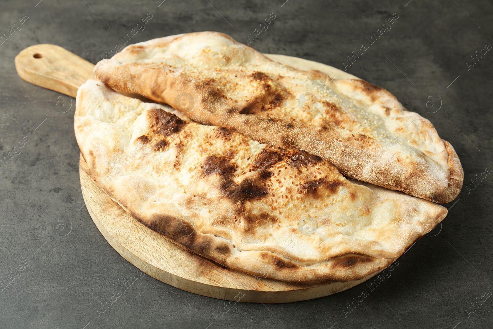 Photo of Delicious calzones on grey textured table, closeup