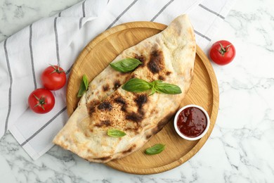 Photo of Delicious calzone served on white marble table, top view