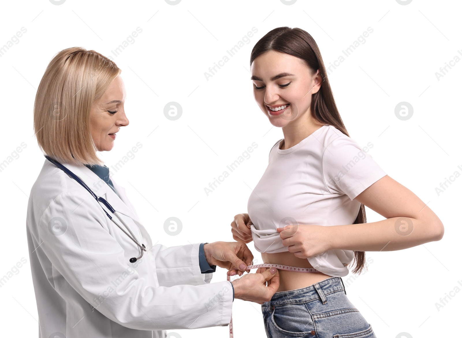 Photo of Happy woman lost weight. Nutritionist measuring patient's waist with tape on white background