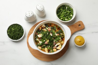 Photo of Delicious okroshka soup and ingredients on white table, flat lay