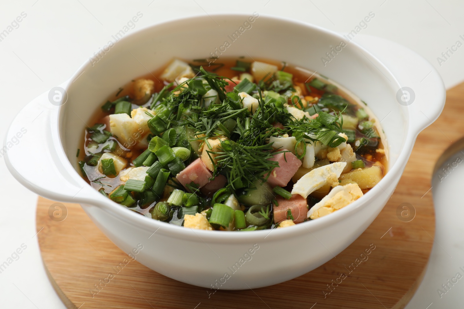 Photo of Delicious okroshka soup with kvass on white table, closeup