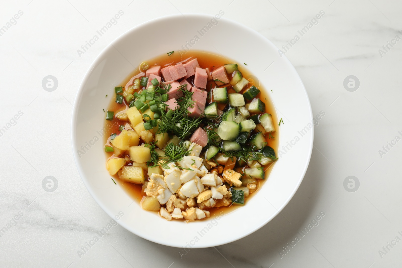 Photo of Delicious okroshka soup with kvass on white table, top view