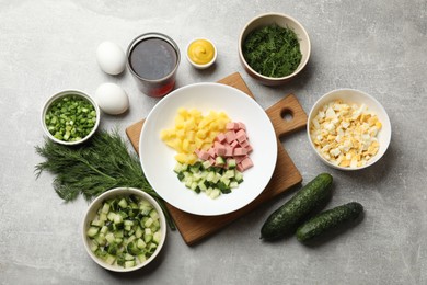 Photo of Different ingredients for okroshka soup on grey table, flat lay