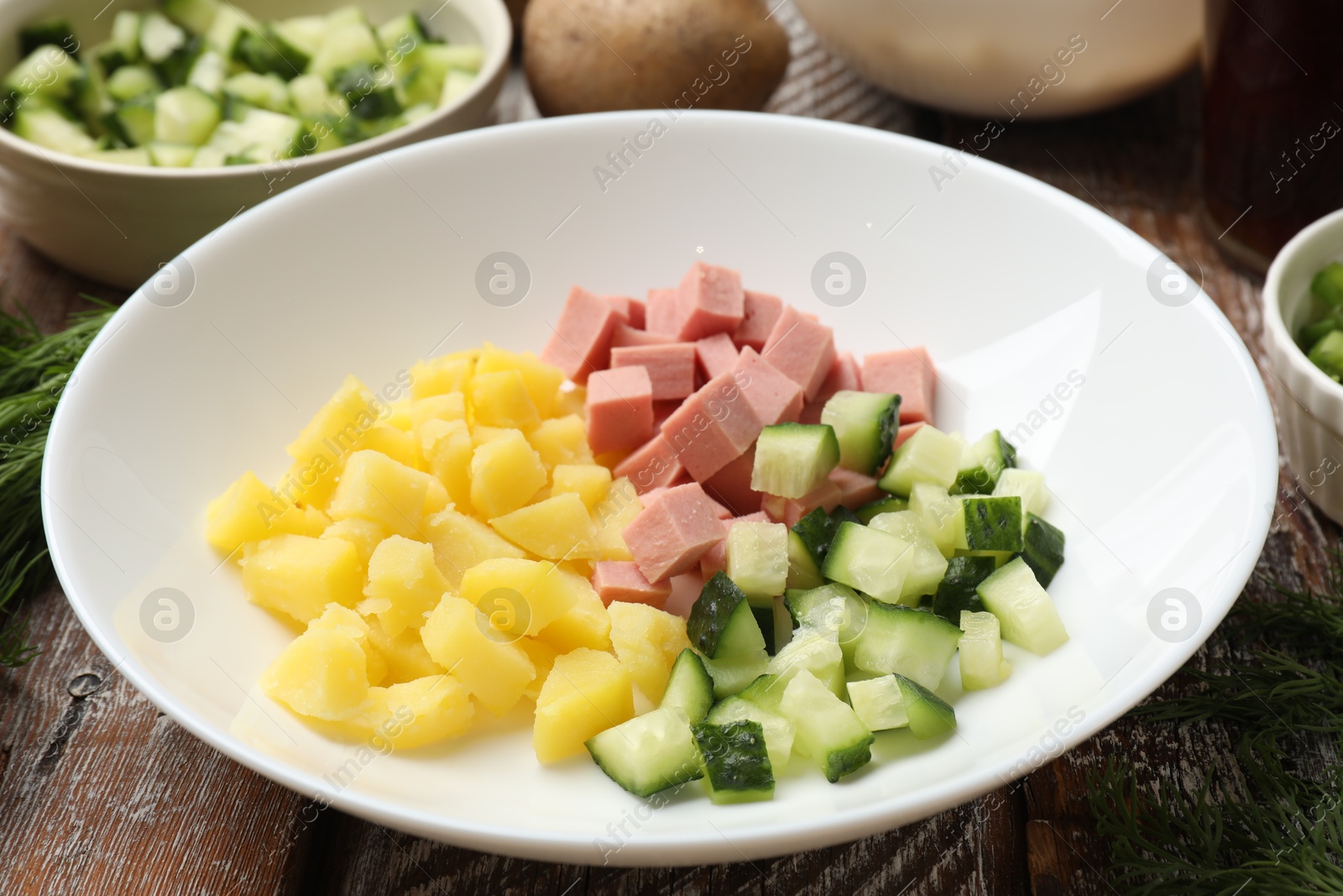 Photo of Different ingredients for okroshka soup on wooden table, closeup