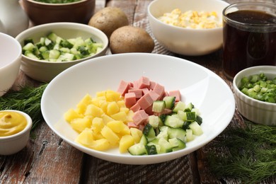 Photo of Different ingredients for okroshka soup on wooden table, closeup