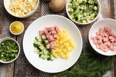 Photo of Different ingredients for okroshka soup on wooden table, flat lay