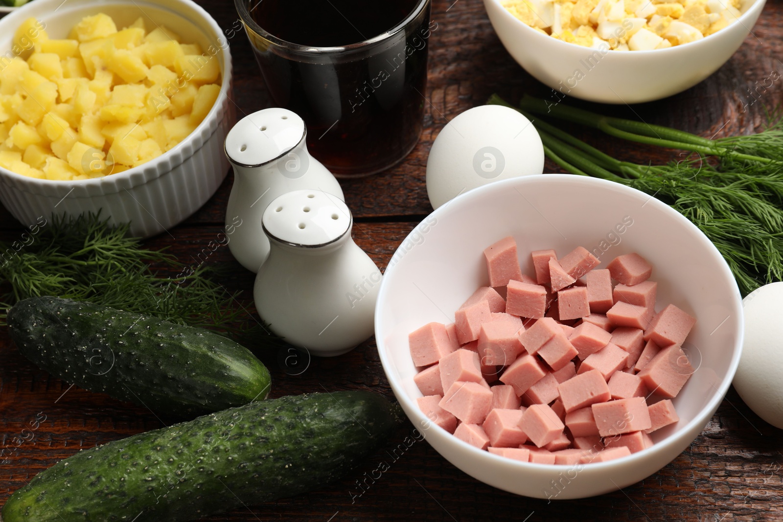 Photo of Different ingredients for okroshka soup on wooden table, closeup