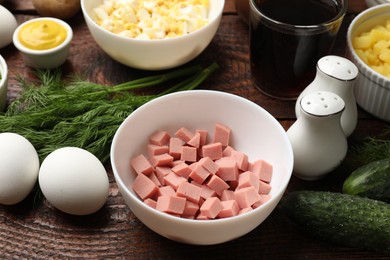 Photo of Different ingredients for okroshka soup on wooden table, closeup