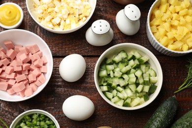 Photo of Different ingredients for okroshka soup on wooden table, flat lay