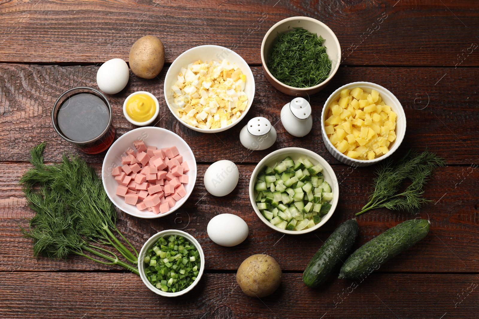 Photo of Different ingredients for okroshka soup on wooden table, flat lay