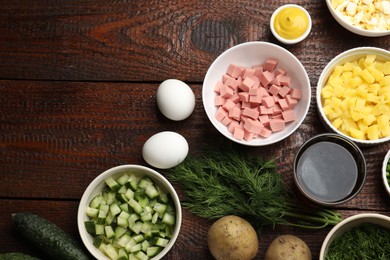 Photo of Different ingredients for okroshka soup on wooden table, flat lay. Space for text