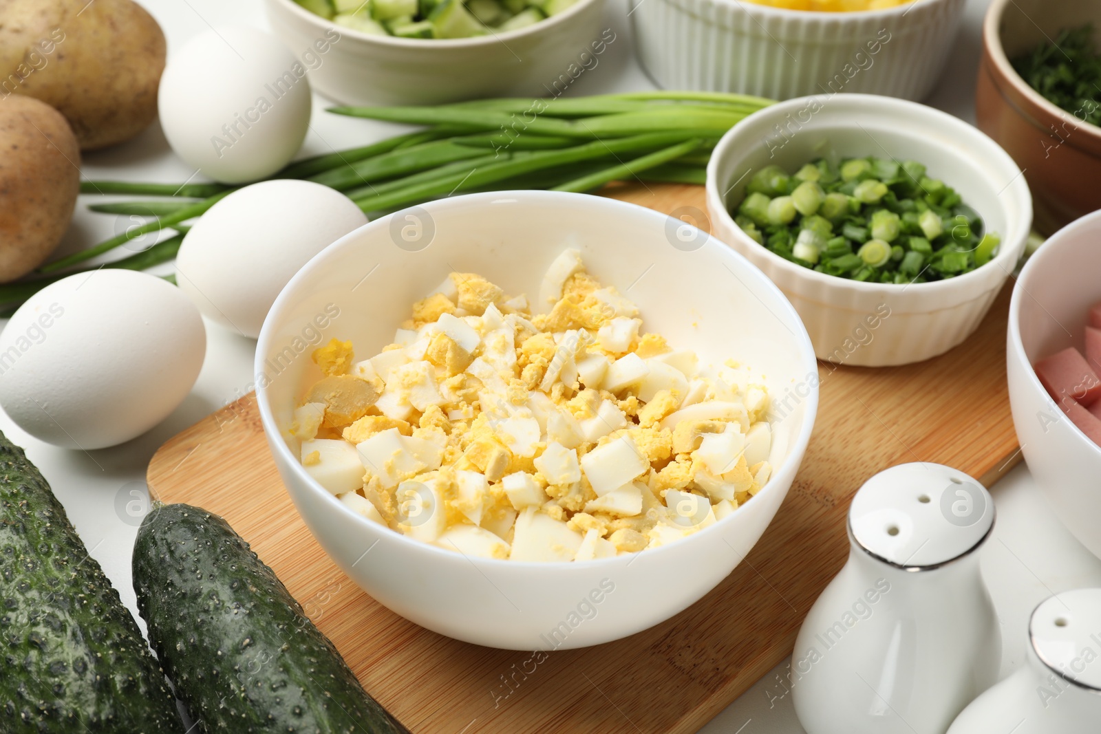 Photo of Different ingredients for okroshka soup on white table, closeup